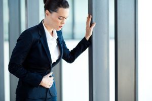 Woman having stomach ache in office