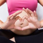 pregnant woman making heart with hands
