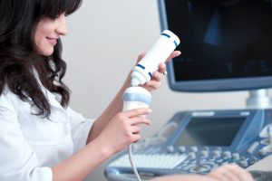 female doctor squeezing special gel from tube to scan